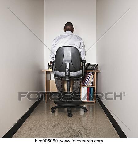 Stock Image - African businessman working in small office. Fotosearch