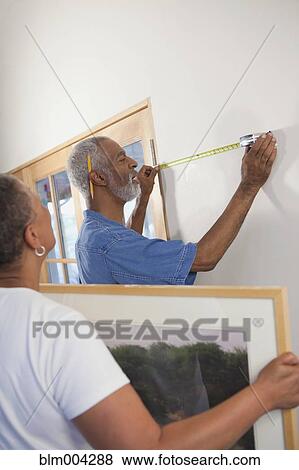 African couple hanging picture on wall View Large Photo Image Stock Photo - African couple hanging picture on wall. Fotosearch
