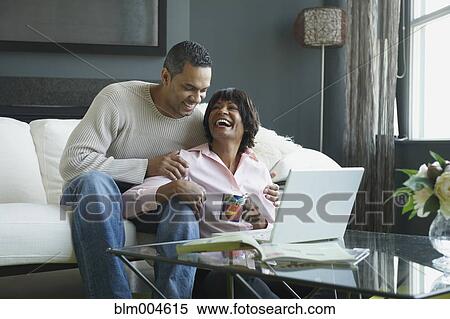 African couple laughing and looking at laptop View Large Photo Image Stock Photography - African couple laughing and looking at laptop. Fotosearch