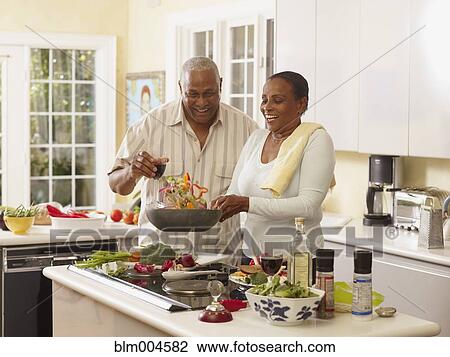 Stock Image - African couple preparing healthy meal. Fotosearch