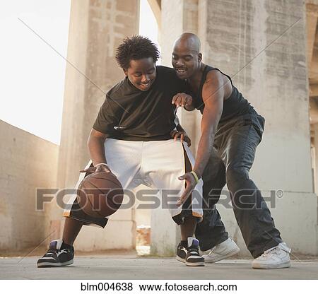 Stock Photo - African father playing basketball with son. Fotosearch