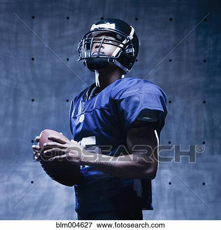 Stock Photo - African football player holding football. Fotosearch