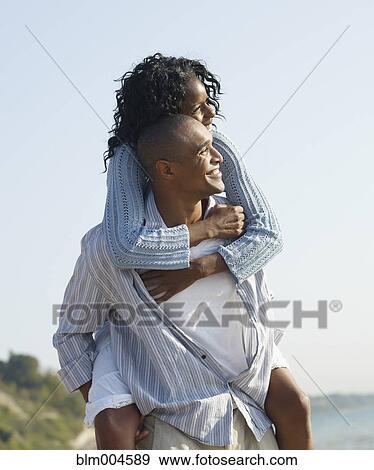 African man giving girlfriend piggy back ride View Large Photo Image Stock Photo - African man giving girlfriend piggy back ride. Fotosearch