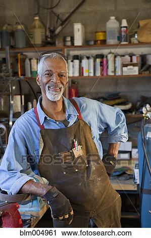 Stock Image - African man in metal shop. Fotosearch