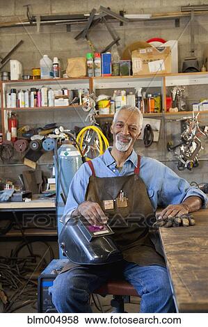 Stock Photo - African man in metal shop. Fotosearch