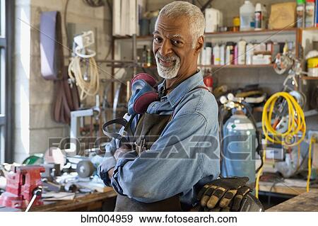 Stock Photo - African man in metal shop. Fotosearch