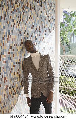 African man in tweed jacket leaning against tiled wall View Large Photo Image Picture - African man in tweed jacket leaning against tiled wall. Fotosearch