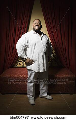 Stock Photo - African man posing near curtain. Fotosearch