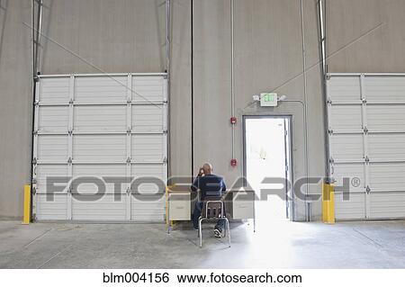 African man working at desk at warehouse loading dock View Large Photo Image Stock Photograph - African man working at desk at warehouse loading dock. Fotosearch