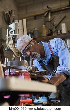 African man working in metal shop View Large Photo Image Stock Image - African man working in metal shop. Fotosearch