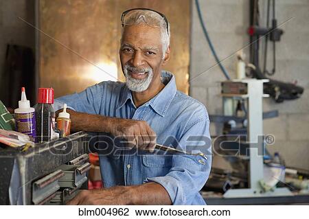 African man working in metal shop View Large Photo Image Stock Image - African man working in metal shop. Fotosearch