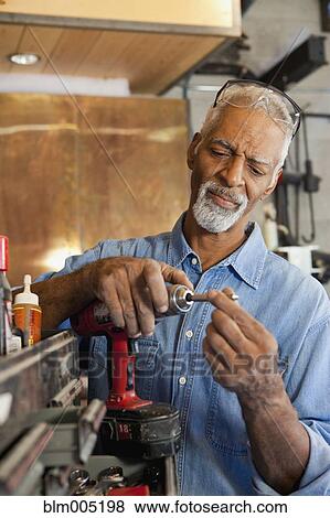Stock Photo - African man working in metal shop. Fotosearch