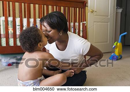 Stock Image - African mother playing with young son. Fotosearch