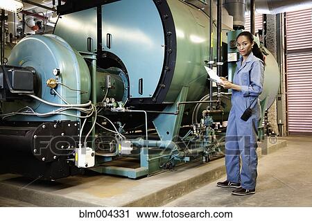 African technician standing next to machinery View Large Photo Image Stock Image - African technician standing next to machinery. Fotosearch