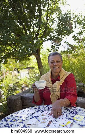 African woman drinking coffee and playing cards View Large Photo Image Stock Photo - African woman drinking coffee and playing cards. Fotosearch