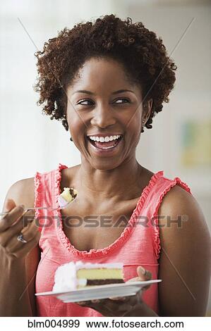 African woman eating cake View Large Photo Image Stock Photo - African woman eating cake. Fotosearch