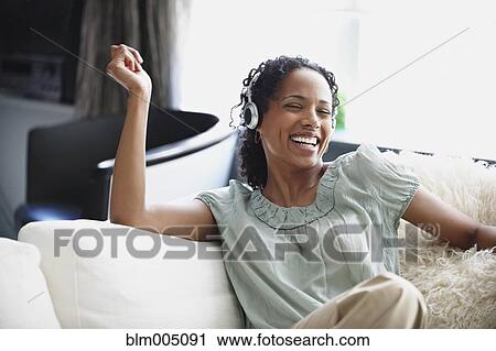 African woman enjoying listening to headphones View Large Photo Image Stock Image - African woman enjoying listening to headphones. Fotosearch