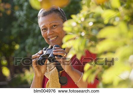 African woman holding binoculars View Large Photo Image Stock Photograph - African woman holding binoculars. Fotosearch