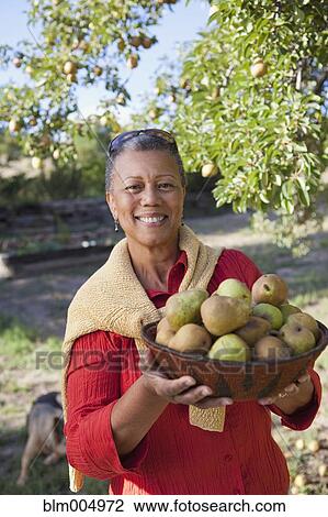 African woman holding bowl of pears View Large Photo Image Stock Image - African woman holding bowl of pears. Fotosearch