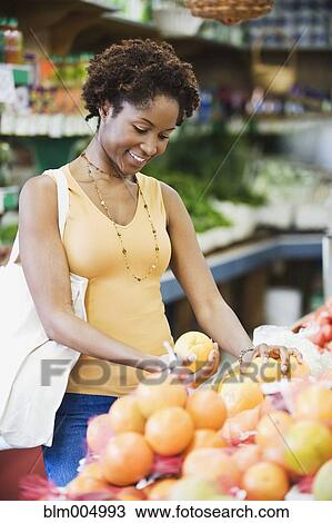 African woman picking fruit in market View Large Photo Image Stock Image - African woman picking fruit in market. Fotosearch