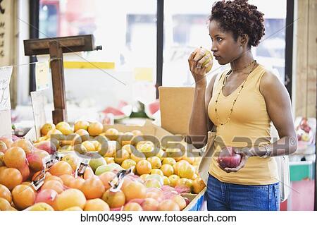 African woman picking fruit in market View Large Photo Image Stock Photography - African woman picking fruit in market. Fotosearch