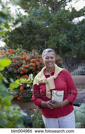 Stock Photography - African woman standing in garden. Fotosearch