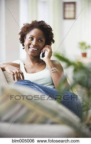 African woman talking on cell phone in living room View Large Photo Image Stock Photograph - African woman talking on cell phone in living room. Fotosearch