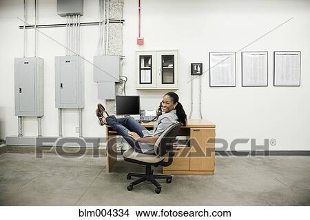 African woman talking on telephone in warehouse View Large Photo Image Picture - African woman talking on telephone in warehouse. Fotosearch