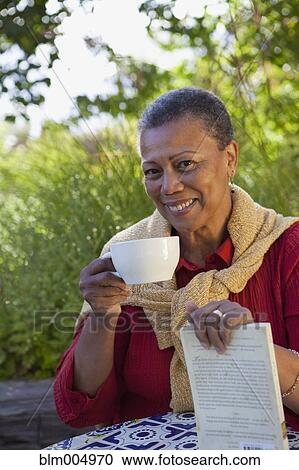 African woman with book drinking coffee View Large Photo Image Stock Image - African woman with book drinking coffee. Fotosearch