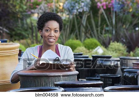Stock Photo - African woman working in garden nursery. Fotosearch
