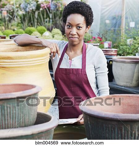 Stock Photo - African woman working in garden nursery. Fotosearch