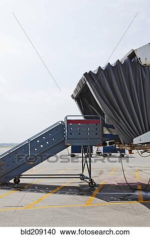 Airplane passenger boarding bridge on runway View Large Photo Image Stock Image - Airplane passenger boarding bridge on runway. Fotosearch
