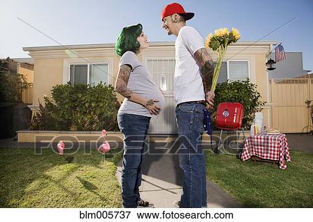 Alternative Hispanic husband giving pregnant wife flowers View Large Photo Image Stock Photo - Alternative Hispanic husband giving pregnant wife flowers. Fotosearch