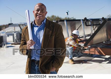 Architect and construction worker on rooftop near solar panels View Large Photo Image Picture - Architect and construction worker on rooftop near solar panels. Fotosearch