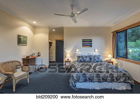 Stock Image - Armchair and bed in hotel room. Fotosearch