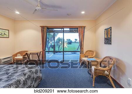 Stock Image - Armchair and bed in hotel room. Fotosearch