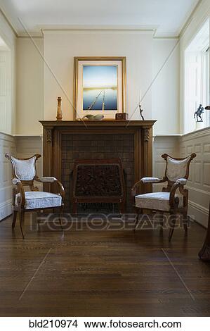 Armchairs and mantle piece in living room View Large Photo Image Picture - Armchairs and mantle piece in living room. Fotosearch
