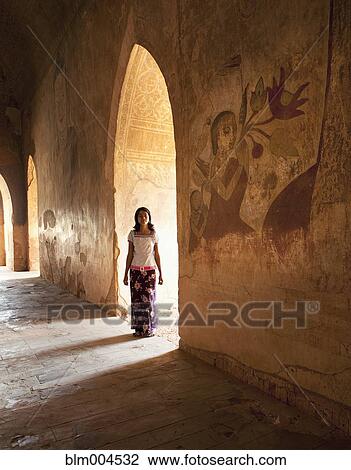 Stock Image - Asian girl standing in archway. Fotosearch