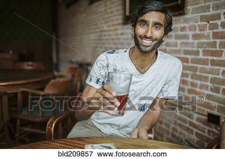 Asian man drinking beer in pub View Large Photo Image Stock Photo - Asian man drinking beer in pub. Fotosearch