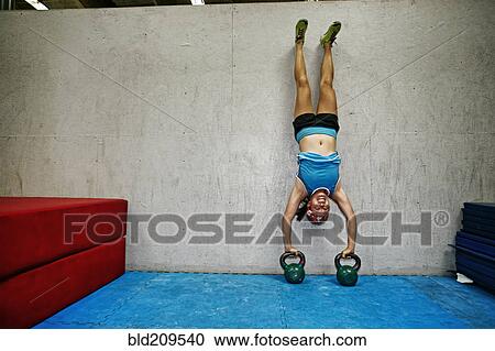 Stock Image - Asian woman exercising in gym. Fotosearch