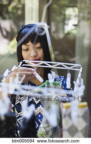 Asian woman hanging laundry out to dry View Large Photo Image Picture - Asian woman hanging laundry out to dry. Fotosearch