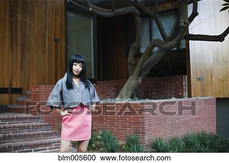 Asian woman standing outside house View Large Photo Image Stock Image - Asian woman standing outside house. Fotosearch