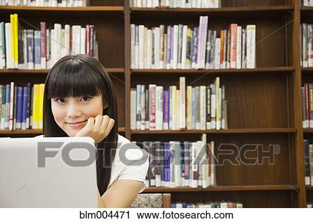 Asian woman using laptop in library View Large Photo Image Stock Image - Asian woman using laptop in library. Fotosearch