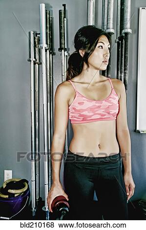 Stock Photo - Asian woman working out in gym. Fotosearch