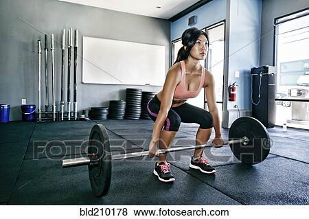 Stock Photo - Asian woman working out in gym. Fotosearch