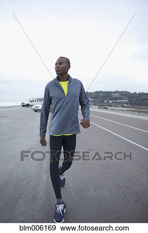 Stock Photo - Athletic Black man walking along road. Fotosearch