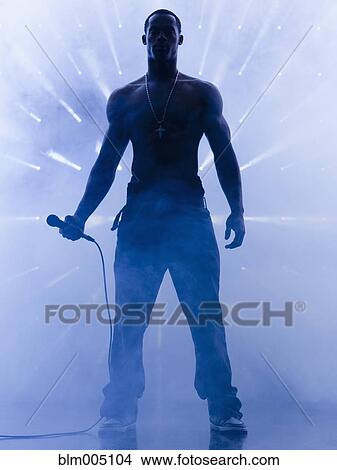Back lit African singer holding microphone View Large Photo Image Picture - Back lit African singer holding microphone. Fotosearch