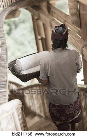 Balinese man carrying rolled towels in hotel, Ubud, Bali, Indonesia View Large Photo Image Stock Photo - Balinese man carrying rolled towels in hotel, Ubud, Bali, Indonesia. Fotosearch