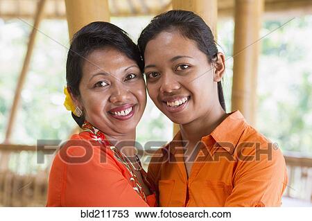 Stock Image - Balinese mother and daughter hugging. Fotosearch