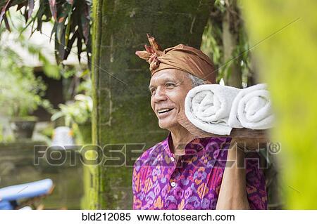 Balinese worker carrying rolled towels View Large Photo Image Stock Photography - Balinese worker carrying rolled towels. Fotosearch
